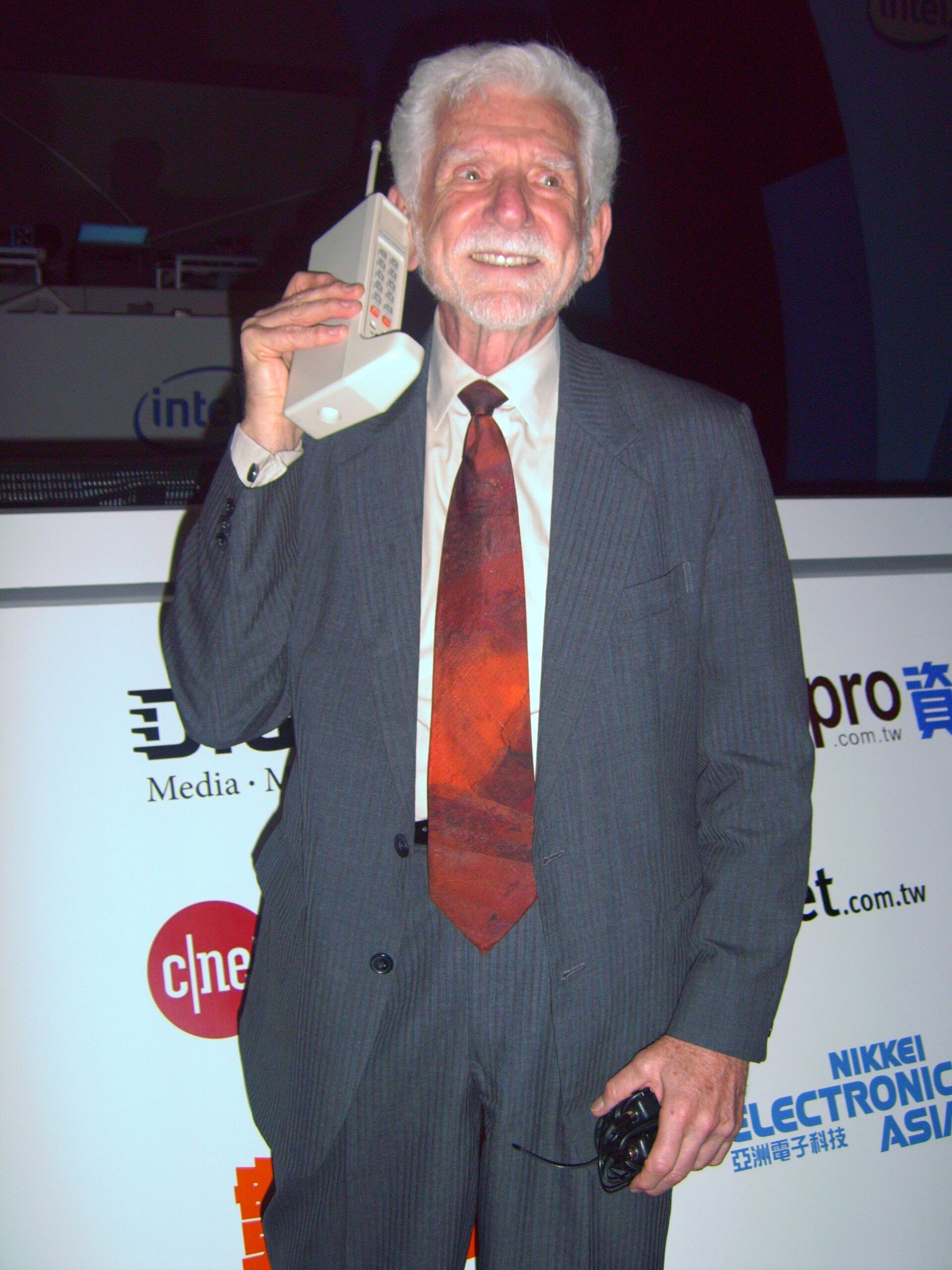 Imagem de referência relacionada a Martin Cooper, item descrito como engenheiro eletricista, criador do telefone celular